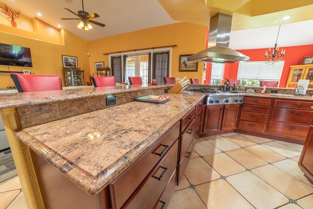 7611 SW 21st Pkwy, Okeechobee, FL 34974 - kitchen with island exhaust hood, stainless steel gas stovetop, healthy amount of natural light, ceiling fan, and high vaulted ceiling