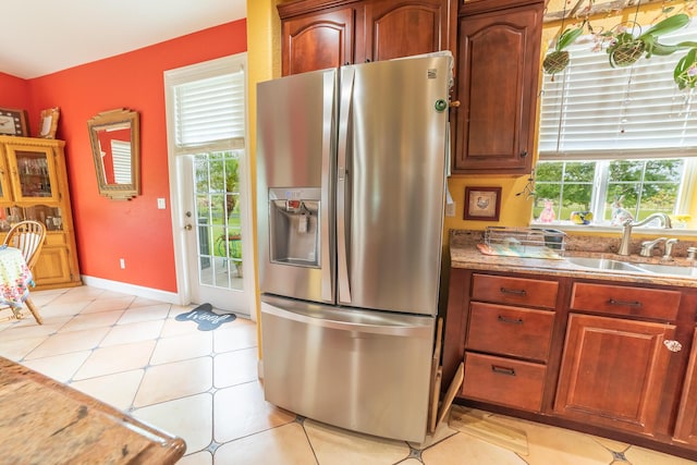 7611 SW 21st Pkwy, Okeechobee, FL 34974 - kitchen featuring stainless steel fridge with ice dispenser, plenty of natural light, light stone counters, and baseboards