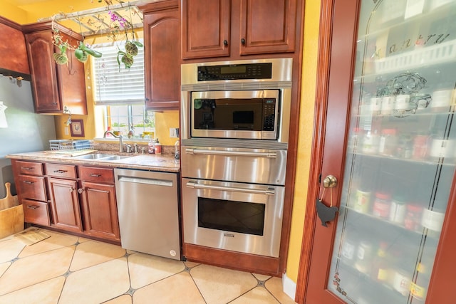 7611 SW 21st Pkwy, Okeechobee, FL 34974 - kitchen featuring appliances with stainless steel finishes, a sink, a warming drawer, and light tile patterned flooring