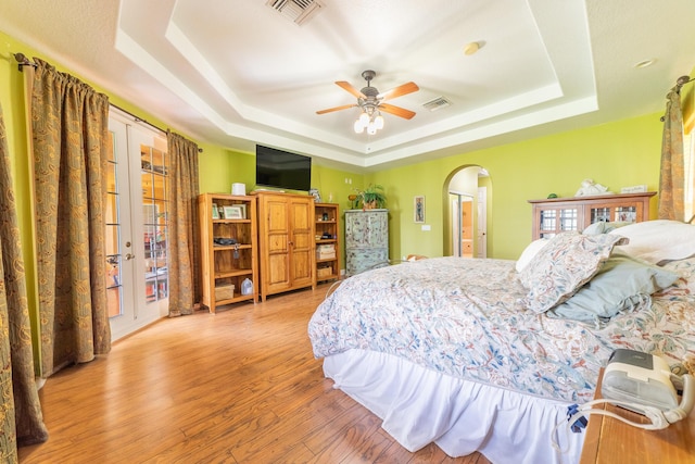 7611 SW 21st Pkwy, Okeechobee, FL 34974 - bedroom with a raised ceiling, arched walkways, light wood-type flooring, and ceiling fan