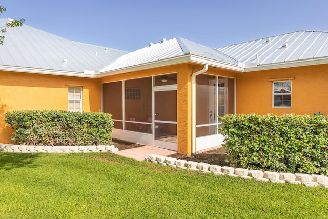 7611 SW 21st Pkwy, Okeechobee, FL 34974 - back of house featuring a sunroom, metal roof, stucco siding, a standing seam roof, and a yard