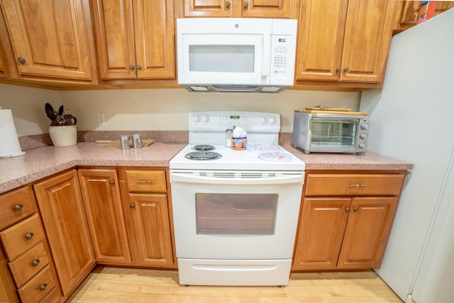 7611 SW 21st Pkwy, Okeechobee, FL 34974 - kitchen with white appliances, light countertops, and brown cabinets