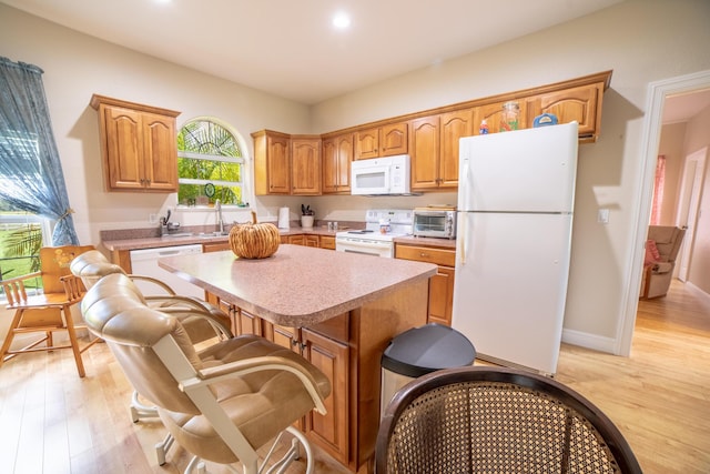7611 SW 21st Pkwy, Okeechobee, FL 34974 - kitchen with white appliances, a center island, light countertops, light wood finished floors, and a sink