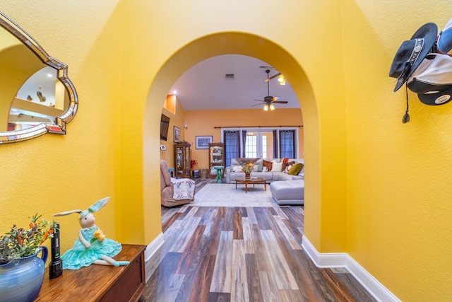 7611 SW 21st Pkwy, Okeechobee, FL 34974 - corridor featuring arched walkways, wood finished floors, a textured wall, and baseboards