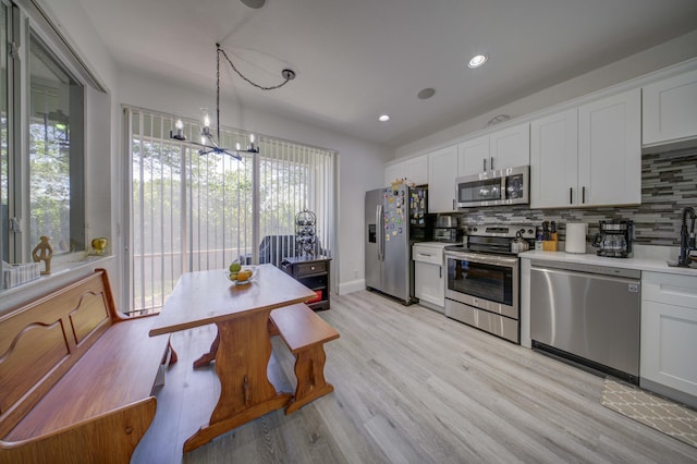 2364 Center Stone Ln, Riviera Beach, FL 33404 - kitchen featuring stainless steel appliances, backsplash, a chandelier, light countertops, and white cabinets
