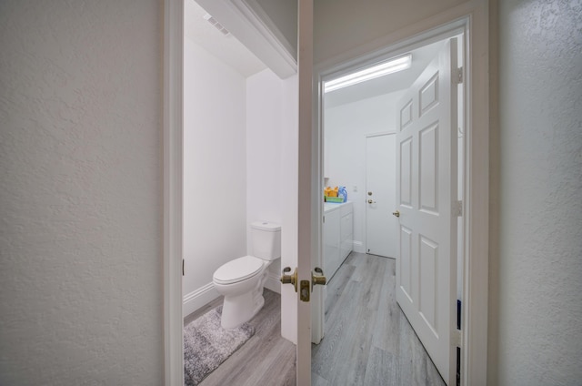 2364 Center Stone Ln, Riviera Beach, FL 33404 - bathroom featuring a textured wall, wood finished floors, toilet, vanity, and independent washer and dryer