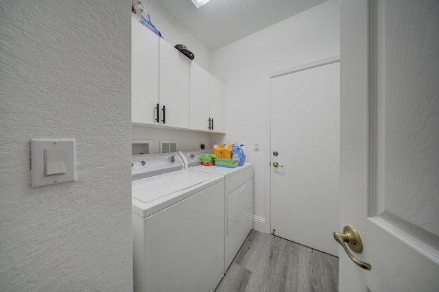 2364 Center Stone Ln, Riviera Beach, FL 33404 - laundry area with washing machine and clothes dryer, cabinet space, and light wood-type flooring