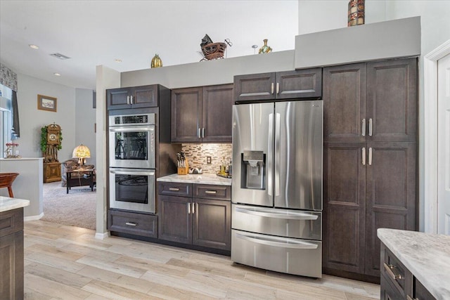 10312 Inverness Way, Port Saint Lucie, FL 34986 - kitchen with stainless steel appliances, dark brown cabinets, light wood finished floors, tasteful backsplash, and recessed lighting