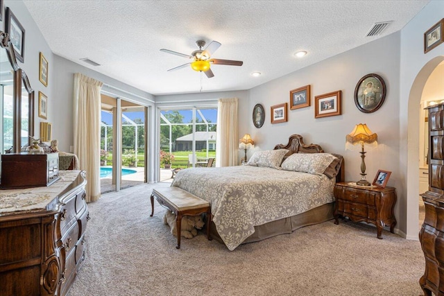 10312 Inverness Way, Port Saint Lucie, FL 34986 - bedroom featuring light colored carpet, access to exterior, arched walkways, a textured ceiling, and ceiling fan