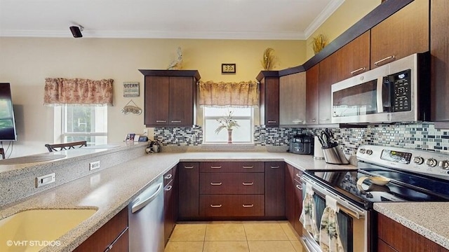 2127 NW Tilia Trl, Stuart, FL 34994 - kitchen featuring stainless steel appliances, tasteful backsplash, crown molding, light tile patterned floors, and a peninsula