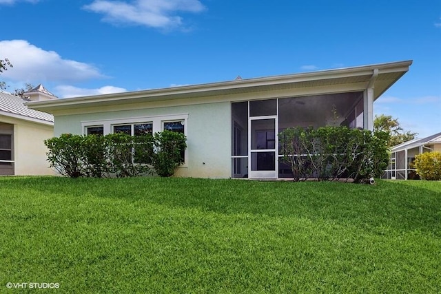 2127 NW Tilia Trl, Stuart, FL 34994 - back of property featuring stucco siding, a yard, and a sunroom