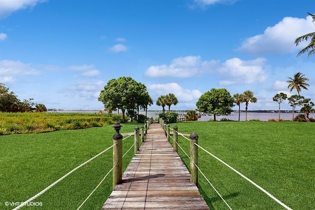 2127 NW Tilia Trl, Stuart, FL 34994 - dock area with a lawn and a water view