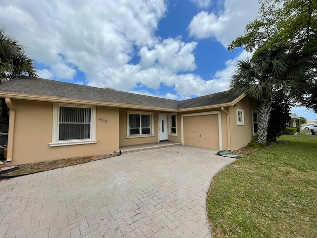 9319 Southampton Pl, Boca Raton, FL 33434 - ranch-style home with stucco siding, a garage, decorative driveway, and a front lawn