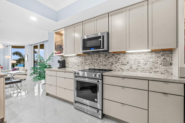 2650 Lake Shore Dr Unit 406, Riviera Beach, FL 33404 - kitchen with appliances with stainless steel finishes, backsplash, ornamental molding, light marble finish flooring, and glass insert cabinets