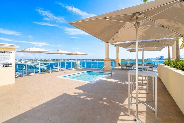 2650 Lake Shore Dr Unit 406, Riviera Beach, FL 33404 - view of swimming pool with a pool, a community hot tub, and a patio area