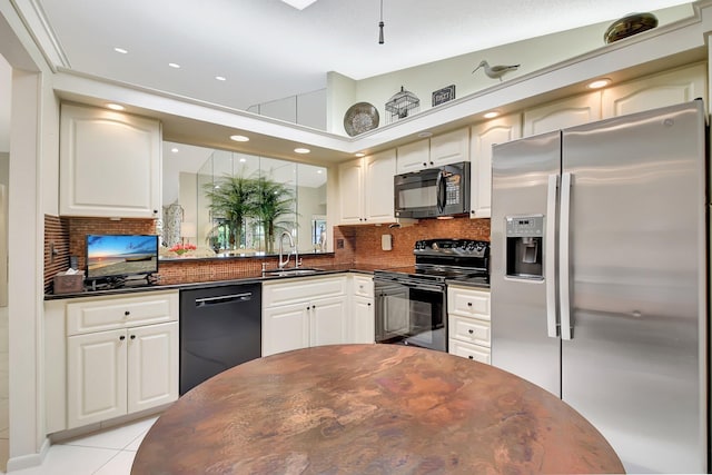 5319 Palmetto Palm Ct Unit A, Boynton Beach, FL 33437 - kitchen with black appliances, dark countertops, tasteful backsplash, white cabinetry, and light tile patterned floors