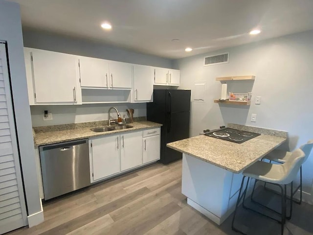 637 Executive Center Dr Unit N207, West Palm Beach, FL 33401 - kitchen with dishwasher, a sink, freestanding refrigerator, stovetop, and a peninsula
