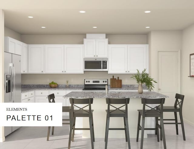 4572 SW Savona Blvd Unit 16, Port Saint Lucie, FL 34953 - kitchen with appliances with stainless steel finishes, white cabinets, light stone counters, recessed lighting, and an island with sink