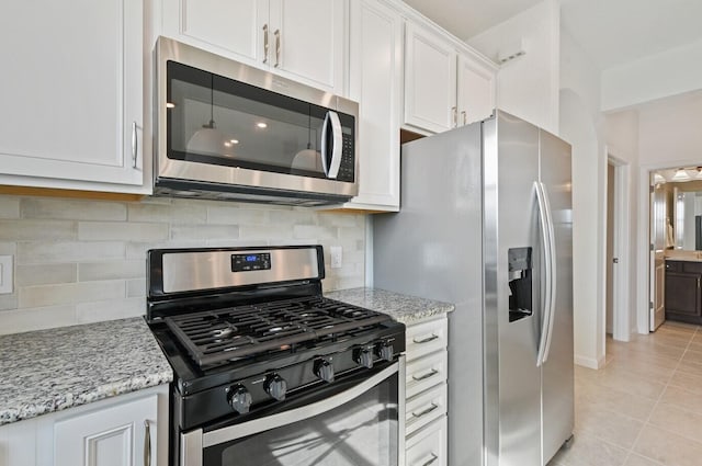 12755 SW Cattleya Ln Unit 224, Port Saint Lucie, FL 34987 - kitchen with stainless steel appliances, white cabinets, light tile patterned floors, and light stone countertops