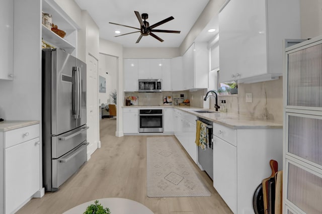 4220 NW 58th Ln, Boca Raton, FL 33496 - kitchen with appliances with stainless steel finishes, ceiling fan, white cabinets, tasteful backsplash, and light wood finished floors