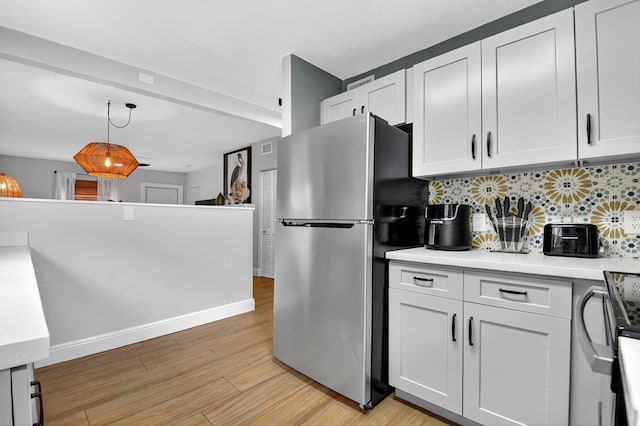 404 S M St Unit 1, Lake Worth Beach, FL 33460 - kitchen with freestanding refrigerator, backsplash, light wood-style floors, light countertops, and white cabinetry