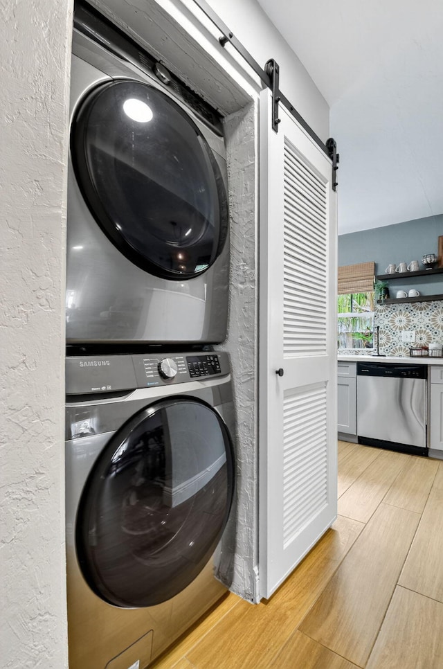 404 S M St Unit 1, Lake Worth Beach, FL 33460 - laundry area with estacked washer and dryer, a barn door, and light wood finished floors