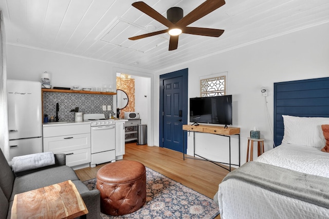 404 S M St Unit 1, Lake Worth Beach, FL 33460 - bedroom with freestanding refrigerator, light wood-type flooring, wet bar, crown molding, and ceiling fan