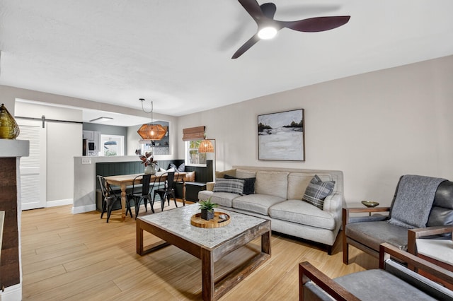 404 S M St Unit 1, Lake Worth Beach, FL 33460 - living room featuring a barn door, ceiling fan, light wood-style floors, and baseboards