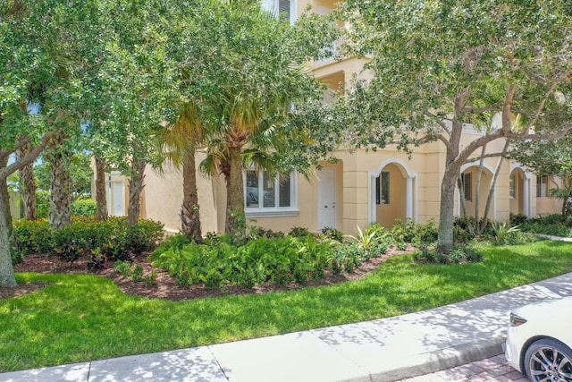 28 Harbour Isle Dr W Unit 101, Fort Pierce, FL 34949 - view of front of property featuring a front lawn and stucco siding