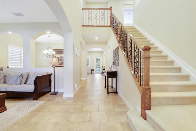 5621 SW Longspur Ln, Palm City, FL 34990 - foyer entrance featuring arched walkways, stairway, baseboards, a towering ceiling, and a chandelier
