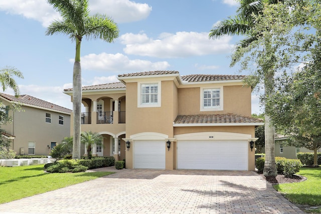 5621 SW Longspur Ln, Palm City, FL 34990 - mediterranean / spanish-style house with an attached garage, a tiled roof, decorative driveway, stucco siding, and a front lawn
