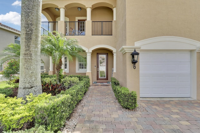 5621 SW Longspur Ln, Palm City, FL 34990 - doorway to property with a garage, stucco siding, a balcony, and driveway