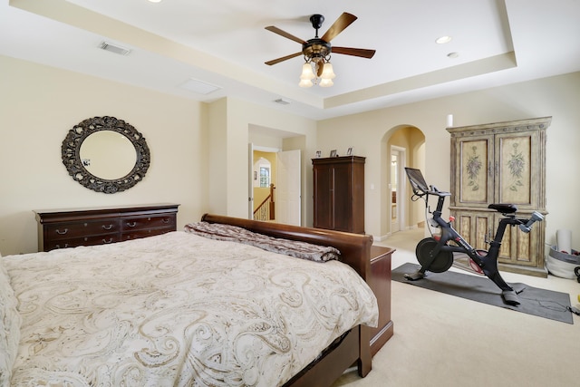 5621 SW Longspur Ln, Palm City, FL 34990 - bedroom with light colored carpet, arched walkways, a tray ceiling, ceiling fan, and recessed lighting