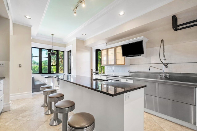 25 Harbor Dr, Lake Worth Beach, FL 33460 - kitchen featuring ornamental molding, a kitchen breakfast bar, a sink, decorative backsplash, and dark countertops