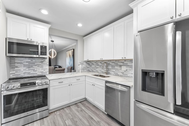 118 Lake Constance Dr Unit 118, West Palm Beach, FL 33411 - kitchen featuring appliances with stainless steel finishes, white cabinetry, light stone counters, light wood-style floors, and tasteful backsplash