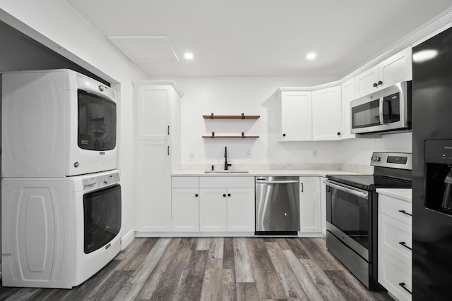 3571 SE Cobia Way, Stuart, FL 34997 - kitchen with appliances with stainless steel finishes, estacked washer and dryer, a sink, light countertops, and white cabinets