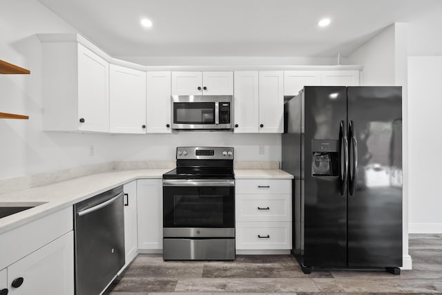 3571 SE Cobia Way, Stuart, FL 34997 - kitchen featuring stainless steel appliances, open shelves, light wood-type flooring, white cabinets, and light countertops