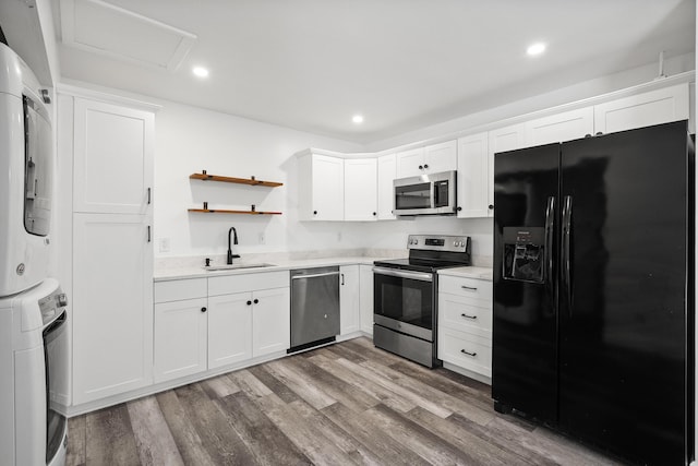 3571 SE Cobia Way, Stuart, FL 34997 - kitchen with appliances with stainless steel finishes, a sink, stacked washer / drying machine, wood finished floors, and light countertops