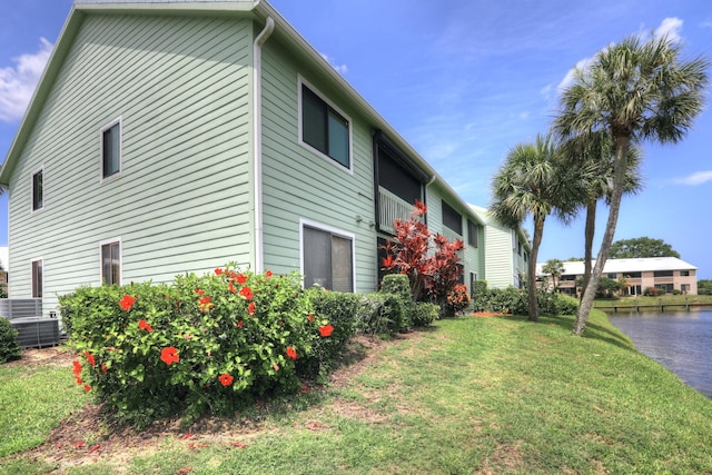 5725 Pelican Pointe Dr Unit 4, Sebastian, FL 32958 - view of home's exterior with a lawn, a water view, and central AC