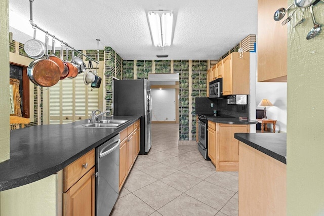 4694 Brady Blvd, Delray Beach, FL 33445 - kitchen featuring appliances with stainless steel finishes, a textured ceiling, dark countertops, light brown cabinetry, and light tile patterned floors