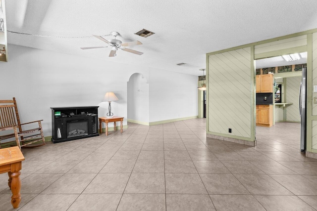 4694 Brady Blvd, Delray Beach, FL 33445 - unfurnished living room with arched walkways, ceiling fan, light tile patterned floors, and a textured ceiling