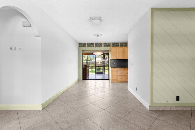 4694 Brady Blvd, Delray Beach, FL 33445 - empty room with light tile patterned floors, arched walkways, and a textured ceiling