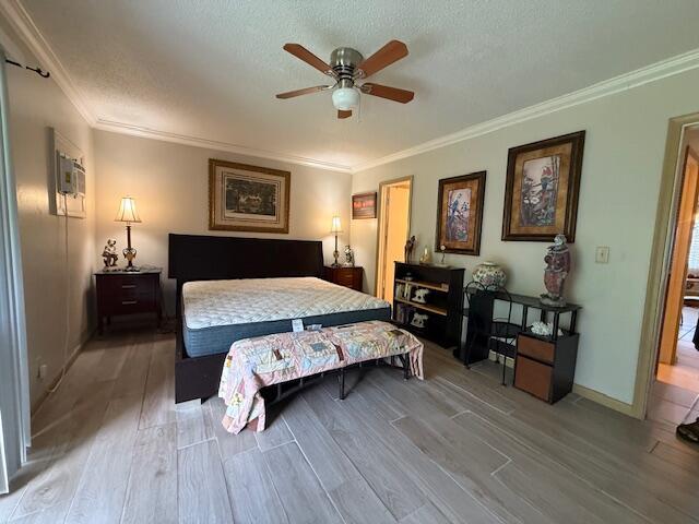 368 Sheffield O, West Palm Beach, FL 33417 - bedroom featuring wood finished floors, crown molding, a textured ceiling, and ceiling fan