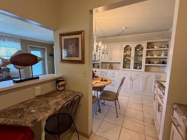 368 Sheffield O, West Palm Beach, FL 33417 - dining space featuring crown molding, a textured ceiling, and light tile patterned floors