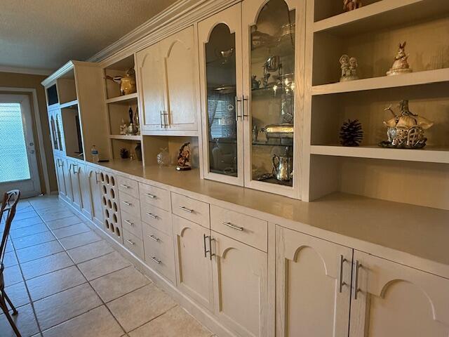 368 Sheffield O, West Palm Beach, FL 33417 - kitchen featuring open shelves, light tile patterned floors, crown molding, light countertops, and built in features