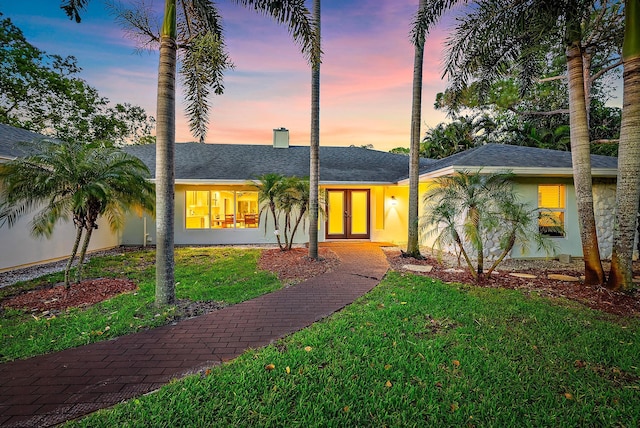 19960 Earlwood Dr, Jupiter, FL 33458 - view of front of property featuring a lawn, a chimney, and french doors