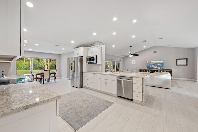 19960 Earlwood Dr, Jupiter, FL 33458 - kitchen featuring stainless steel appliances, open floor plan, vaulted ceiling, white cabinetry, and light stone counters