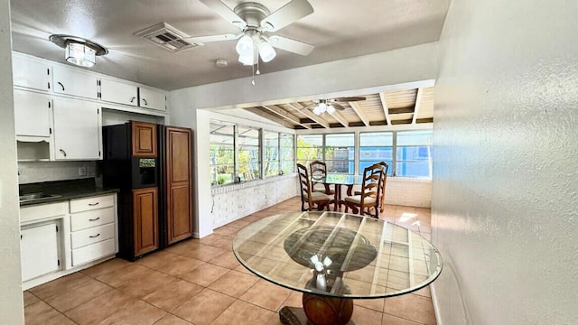 802 Lytle St, West Palm Beach, FL 33405 - dining space with a ceiling fan, light tile patterned flooring, beamed ceiling, and a textured wall