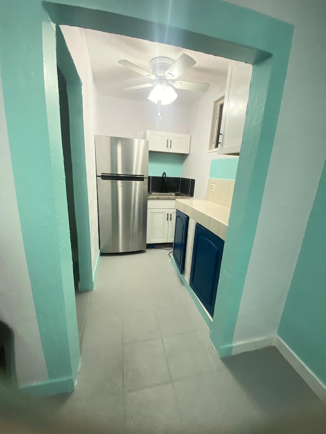 802 Lytle St, West Palm Beach, FL 33405 - kitchen with freestanding refrigerator, white cabinets, light countertops, a sink, and a ceiling fan
