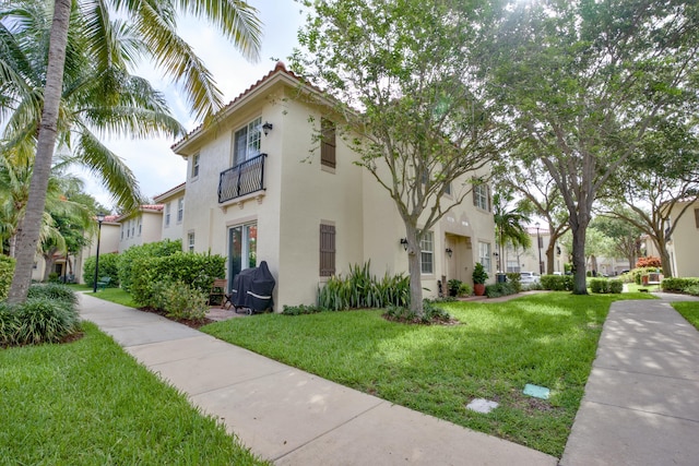 1020 E Longport Cir Unit A1, Delray Beach, FL 33444 - view of property exterior featuring stucco siding, a yard, and a balcony